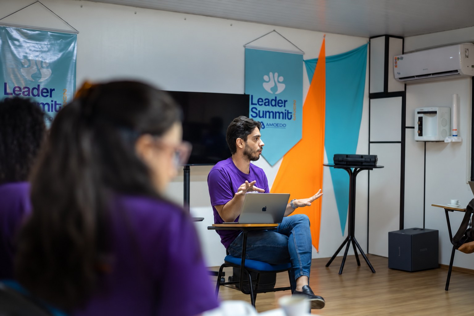 Palestrante conversando com participantes em encontro de liderança da Amoedo